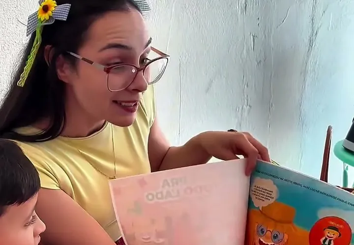 Victória contando a história do milho para as crianças no Arraiá da Nutri